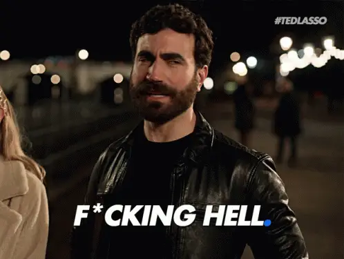 tedlassogifs-roy-kent - Horror Hating Bearded man in a black leather jacket at night with a tense expression; white text overlay reads 'F*CKING HELL'.